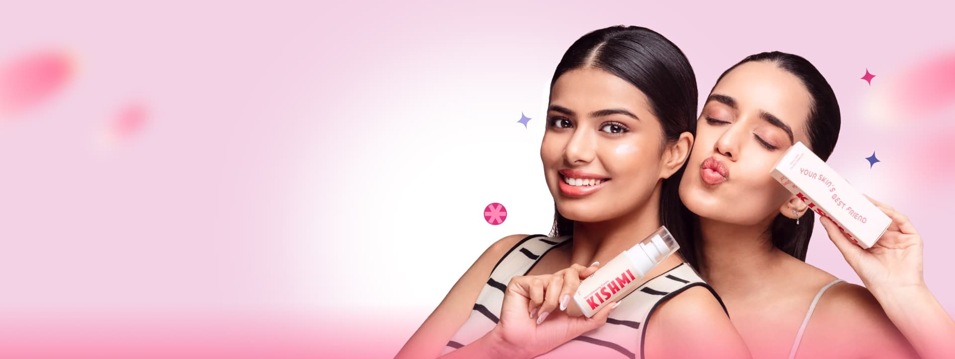 Two women holding Kishmi skincare, one blowing a kiss